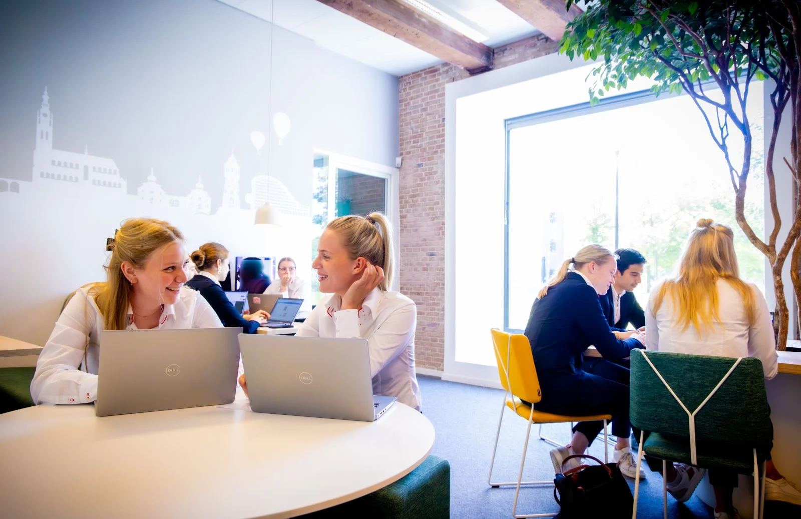 Studenten van het mhbo-traject achter de laptop tijdens een les op school.