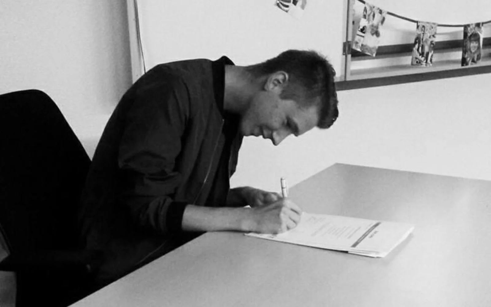 Bradley zet handtekening onder diploma van De Rooi Pannen Tilburg Vmbo.