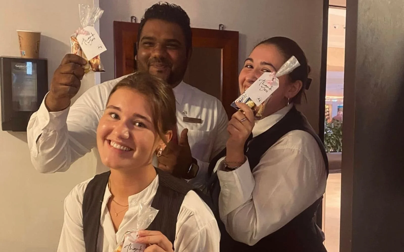 Esmee staat samen met twee collega's lachend op de foto met een ''bedank'' pakketje dat ze ontvangen hebben.