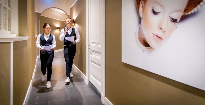 Twee studenten lopen door de gang met hotelkamers van Hotel Nassau.