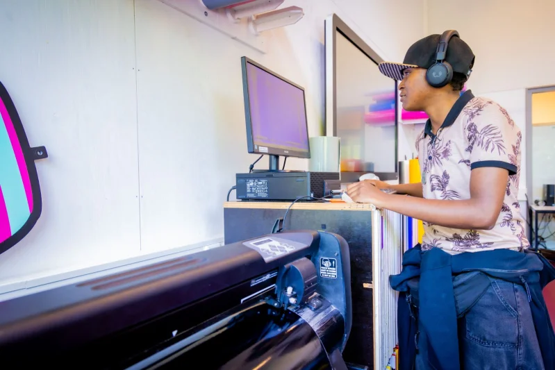 Een student van de mbo-opleiding Signspecialist van De Rooi Pannen Tilburg Vormgeving & Signmaking werkt achter de computer.