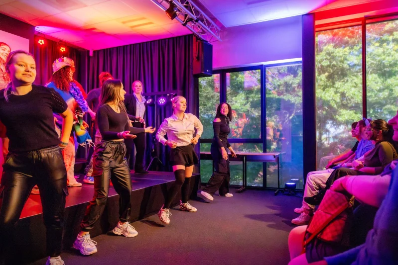 Studenten tijdens een evenement van de opleiding Medewerker evenementen. De studenten dansen.