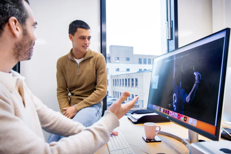 Student van de opleiding Medewerker marketing & communicatie tijdens zijn stage met een collega