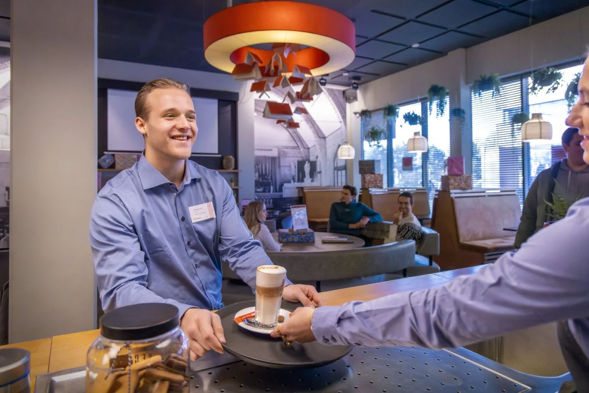 Een student van de mbo-opleiding Retailspecialist doet praktijkervaring op in een lunchroom.