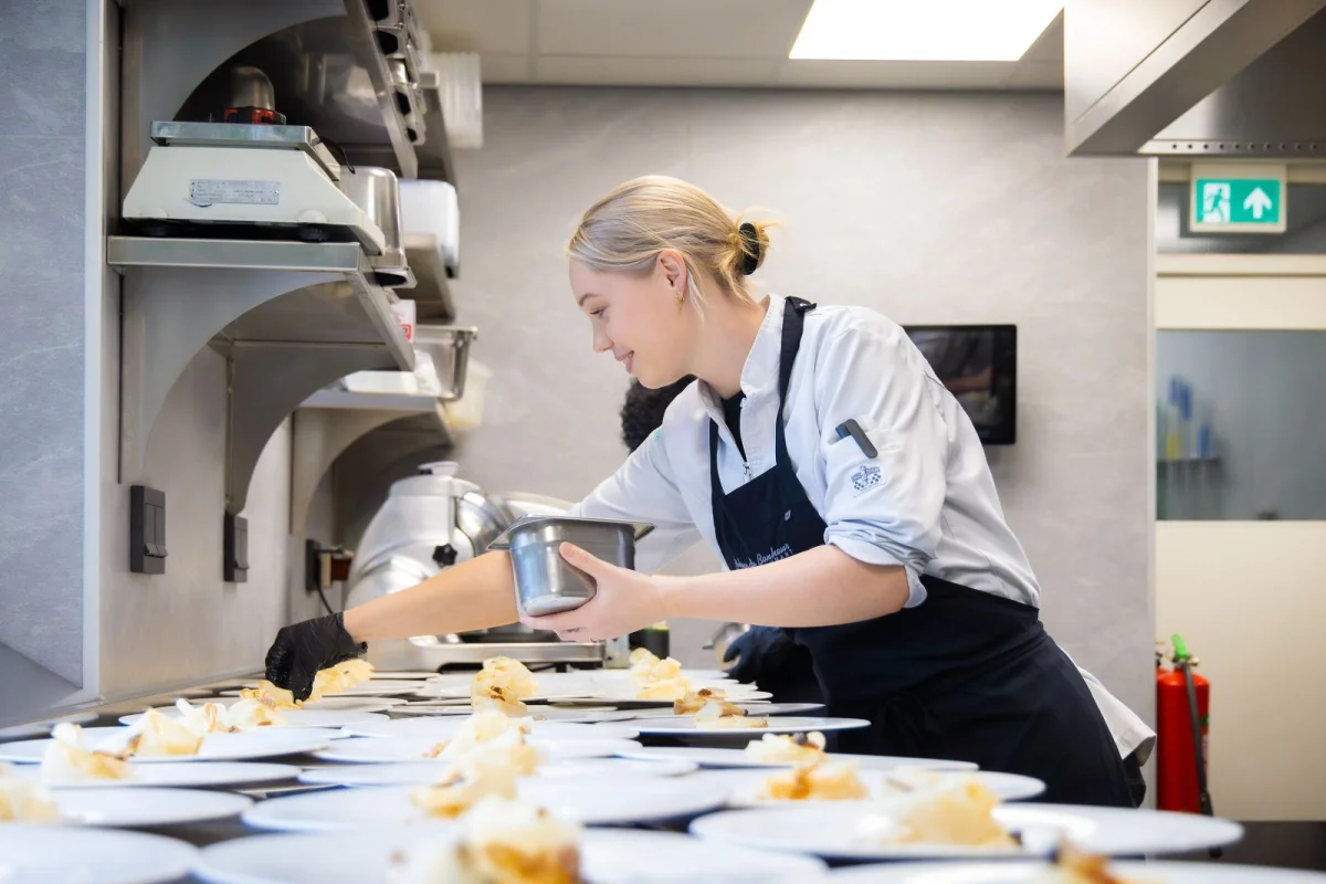 Student tijdens haar BBL-opleiding aan het werk in de keuken bij Bonheur.